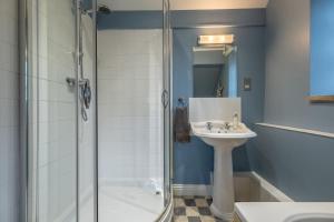 a bathroom with a shower and a sink at Garden Cottage in Ringstead +22 photos
