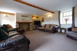 a living room with leather furniture and a fireplace at Hulmes Vale House - Sleeps 14 - Peak district in Buxton