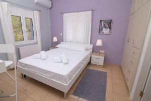 a bedroom with a white bed and a purple wall at Quiet escape in Mikrá Mandínia