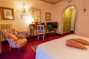 a bedroom with a bed and a desk and a television at Hotel Boccaccio in Calcinaia