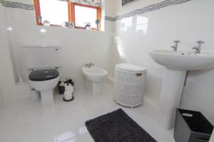 a white bathroom with a toilet and a sink at 2 Priory Court in Thornham +11 photos