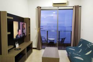 a living room with a television and a balcony with a table at Silverscape Residence Melaka Luxury Seaview Suite - FREE WIFI in Melaka