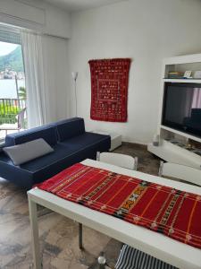 sala de estar con sofá azul y TV en La Casa Sul Lago, en Saló