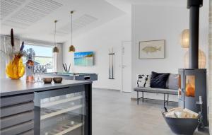 a kitchen with a stove in the middle of a room at Amazing Home In Hvide Sande With Outdoor Swimming Pool in Hvide Sande