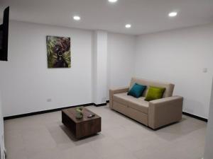 ein Wohnzimmer mit einem Sofa und einem Couchtisch in der Unterkunft Encantador apartamento #2 cerca al aeropuerto in Bogotá