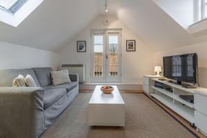 a living room with a couch and a tv at Newgate Boathouse in Wells next the Sea