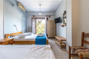 a bedroom with two beds and a window at Villa Zina Agios Dimitrios in Agios Dimitrios