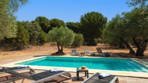 a swimming pool with chaise lounges and chairs around it at Casa Rural Las Catenas Andújar by Ruralidays in Jaén