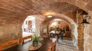 una camera con un muro in pietra e un tavolo con sedie di Casa Rural Las Catenas Andújar by Ruralidays a Jaén