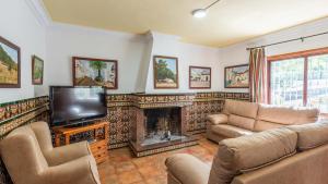 Casa La Fresneda Ubrique by Ruralidays في أوبريق: غرفة معيشة مع تلفزيون ومدفأة