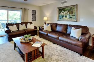 Una sala de estar con un sofá de cuero y una mesa. en Family Gathering Whispering Pines 514, en Pigeon Forge