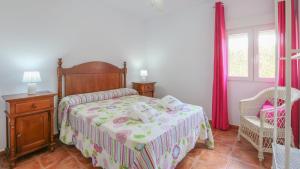 ein Schlafzimmer mit einem Bett und einem Stuhl und einem Fenster in der Unterkunft El Pinar La Puebla de Los Infantes by Ruralidays in La Puebla de los Infantes + 27 Fotos