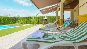 eine Gruppe von Liegestühlen neben einem Swimmingpool in der Unterkunft Villa Sara La Puebla de Los Infantes by Ruralidays in La Puebla de los Infantes