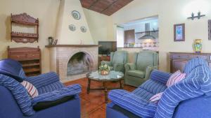ein Wohnzimmer mit blauen Stühlen und einem Kamin in der Unterkunft Villa Sara La Puebla de Los Infantes by Ruralidays in La Puebla de los Infantes