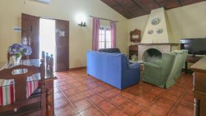 ein Wohnzimmer mit blauen Stühlen und einem Kamin in der Unterkunft Villa Sara La Puebla de Los Infantes by Ruralidays in La Puebla de los Infantes
