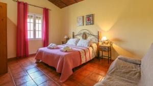 ein Schlafzimmer mit einem Bett und einem Stuhl darin in der Unterkunft Villa Sara La Puebla de Los Infantes by Ruralidays in La Puebla de los Infantes + 19 Fotos