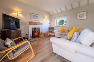 a living room with a couch and a fireplace at Sea Lodge in Brancaster