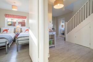 a bedroom with two beds and a staircase at Sea Lodge in Brancaster