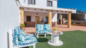 two chairs and a table in front of a house at La Antigua Fábrica Teba by Ruralidays in Teba
