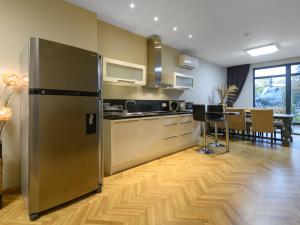 a kitchen with a stainless steel refrigerator and a dining room at Beachfront 3-bedroom apartment with jaccuzi and barbecue in the back in Varna City