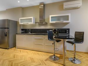 a kitchen with a table and two bar stools at Beachfront 3-bedroom apartment with jaccuzi and barbecue in the back in Varna City