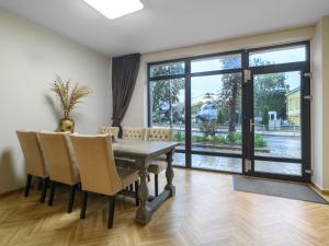 a dining room with a table and chairs and a large window at Beachfront 3-bedroom apartment with jaccuzi and barbecue in the back in Varna City