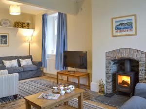 a living room with a couch and a fireplace at Tyllwyd Farmhouse in Capel Bangor