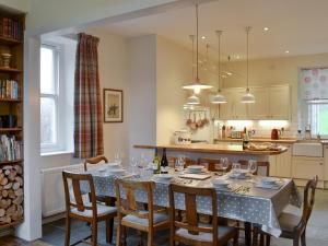 a kitchen and dining room with a table and chairs at Tyllwyd Farmhouse in Capel Bangor