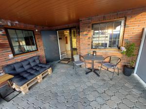 a patio with a couch and a table and chairs at In Love With Norway in Larvik