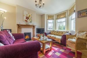 a living room with purple furniture and a fireplace at 4 Harbour View in Brancaster