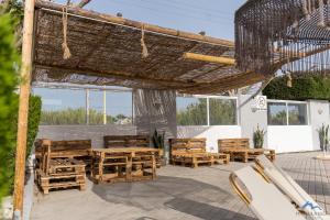 an outdoor patio with wooden tables and chairs at Casa Blue Sarantis in Faliraki