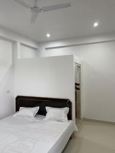 1 dormitorio blanco con 1 cama con 2 almohadas en OYO Hotel Red Cross(banquet&restra) en Kānpur