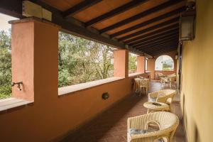 a porch with chairs and tables and windows at Hotel Boccaccio in Calcinaia