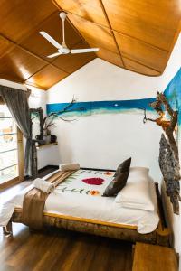 Cama en habitación con techo de madera en RISING SUN BEACH VIEW, en Thinadhoo