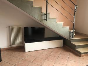 - un salon avec une télévision sous un escalier dans l'établissement Bondion Apartment, à Sandrà
