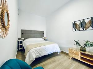 1 dormitorio con 1 cama grande y 1 mesa en Apartamentos Turísticos Santo Rostro en Chipiona