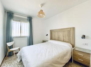 チピオナにあるApartamentos Turísticos Santo Rostroのベッドルーム(大きな白いベッド1台、椅子付)