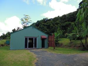 un edificio verde con una puerta en un campo en Bellview en Bellthorpe