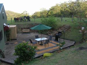 a patio with a table and chairs and an umbrella at Bellview in Bellthorpe
