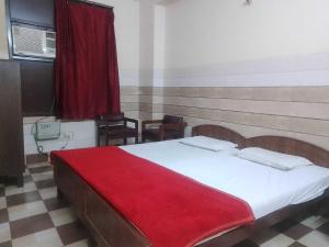 een slaapkamer met een bed met een rode deken erop bij OYO Ram Krishna Palace in Lucknow