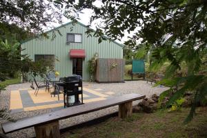 a green building with a picnic table and a grill at Bellview in Bellthorpe