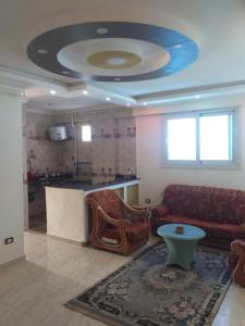 a living room with a couch and a table at شقة فندقية - رؤية واضحة للبحر - ابوقير - الاسكندرية in Abū Qīr