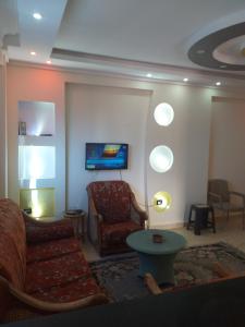 a living room with a couch and a chair at شقة فندقية - رؤية واضحة للبحر - ابوقير - الاسكندرية in Abū Qīr