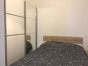 1 dormitorio con cama y espejo en Le gite bleu, en Ax-les-Thermes