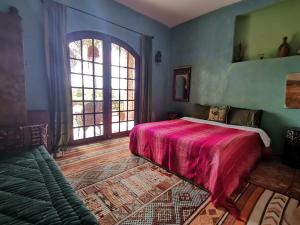 ein Schlafzimmer mit einem Bett und einem großen Fenster in der Unterkunft Hajrienne guest house in Tangier