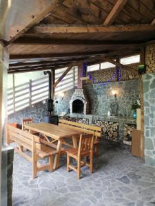 ein Esszimmer mit einem Holztisch und einer Steinmauer in der Unterkunft Casa Din Padure in Sinaia