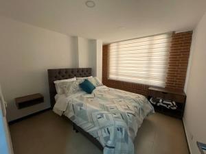 ein Schlafzimmer mit einem großen Bett mit Fenster in der Unterkunft Encantador apartamento #3 cerca al aeropuerto in Bogotá + 2 Fotos