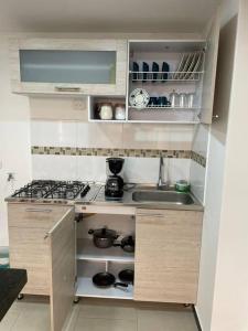 eine kleine Küche mit Spüle und Herd in der Unterkunft Encantador apartamento #3 cerca al aeropuerto in Bogotá