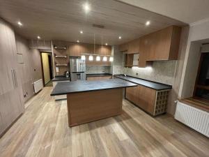 a large kitchen with wooden cabinets and a large island at Departamento Valle Nevado Ski Resort Chile Ski in - Ski out in Valle Nevado