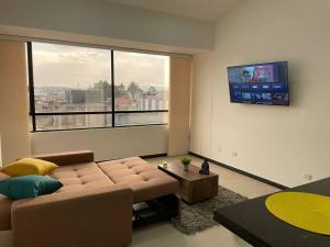 ein Wohnzimmer mit Couch und Flachbildfernseher in der Unterkunft Encantador apartamento #3 cerca al aeropuerto in Bogotá